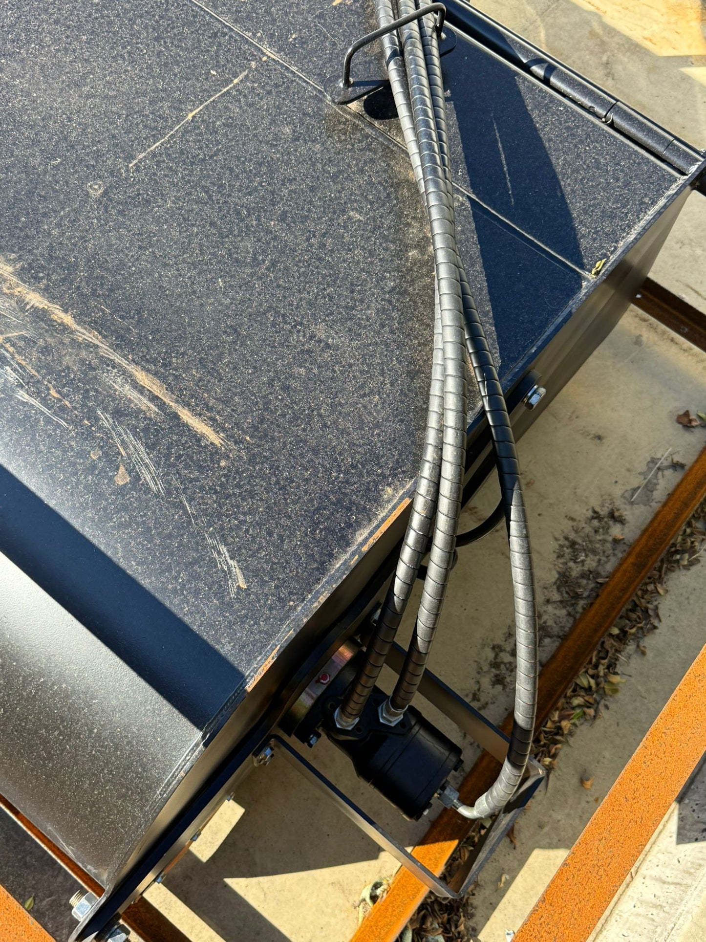 Close-up view of Labadi Engineering Hydraulic Skid Steer Sweeper showing hydraulic hoses and metal components