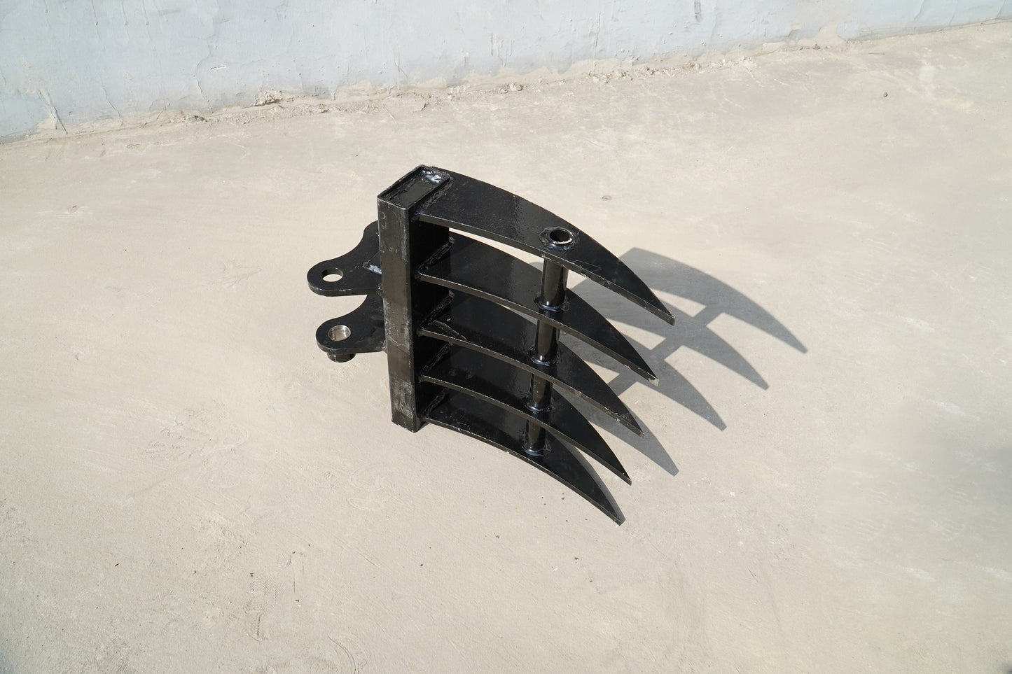 Rippa Australia black Excavator Rake attachment with curved tines on concrete floor