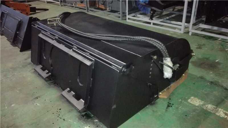 Labadi Engineering Hydraulic Skid Steer Sweeper attachment in black with hydraulic hoses on factory floor