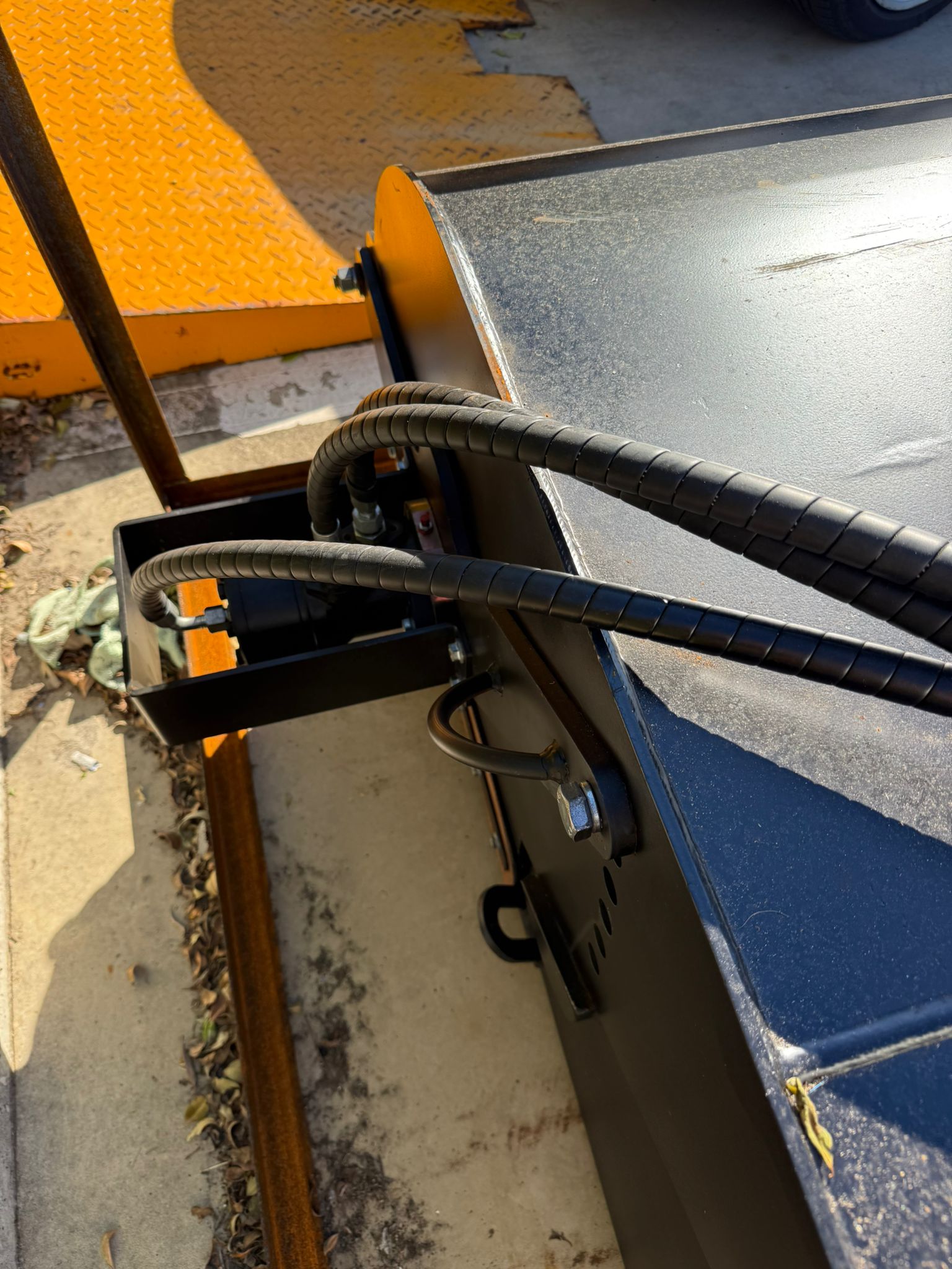 Close-up of hydraulic hoses and metal components on Labadi Engineering Hydraulic Skid Steer Sweeper