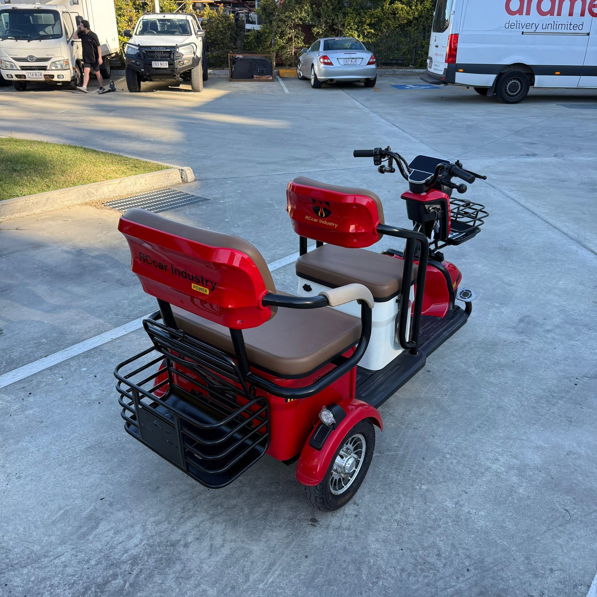 Labadi Engineering red Wheel Trike with two seats and black metal baskets on a concrete surface
