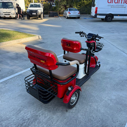 Labadi Engineering red Wheel Trike with two seats and black metal baskets on a concrete surface