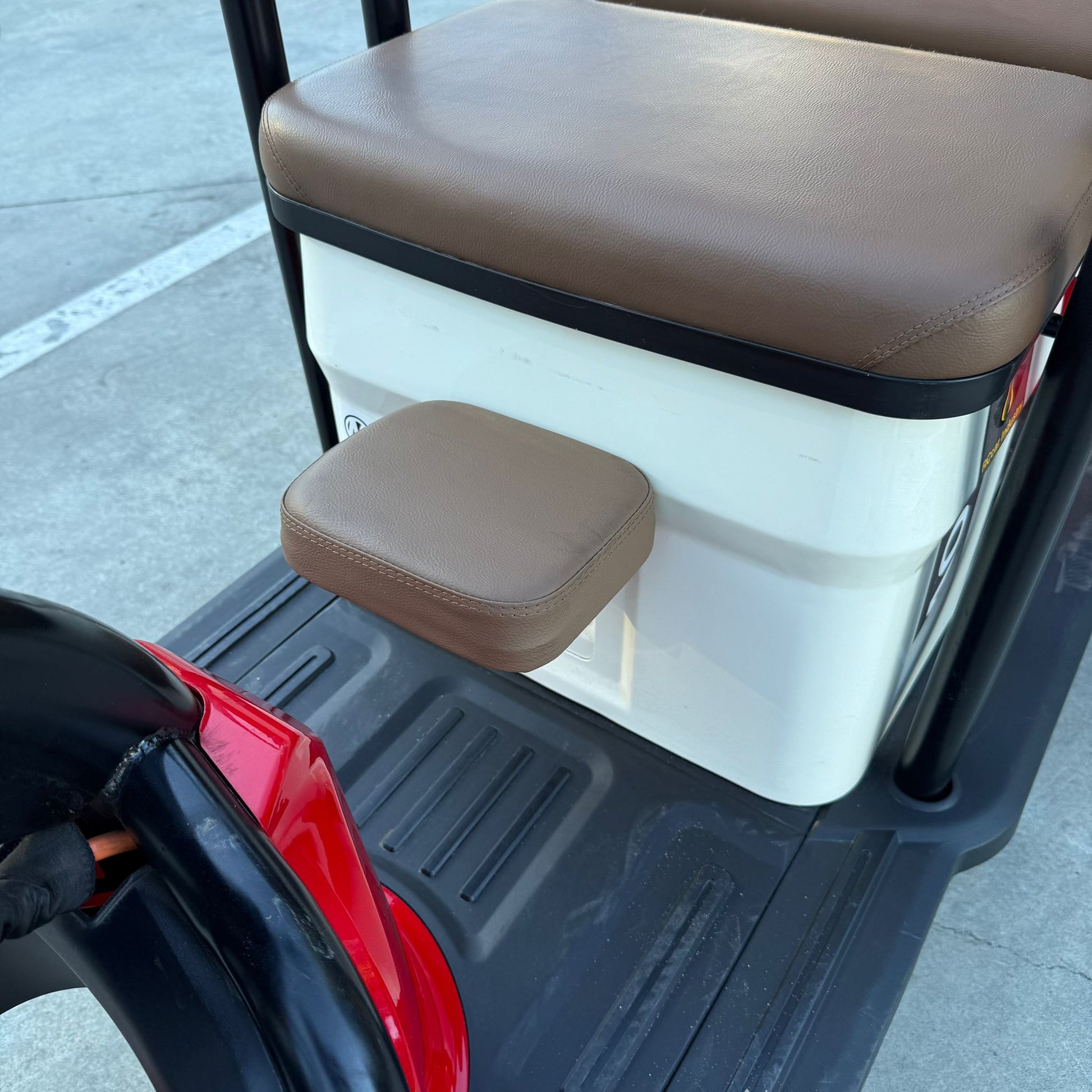 Close-up of Labadi Engineering Wheel Trike brown seat and footrest on black floor mat
