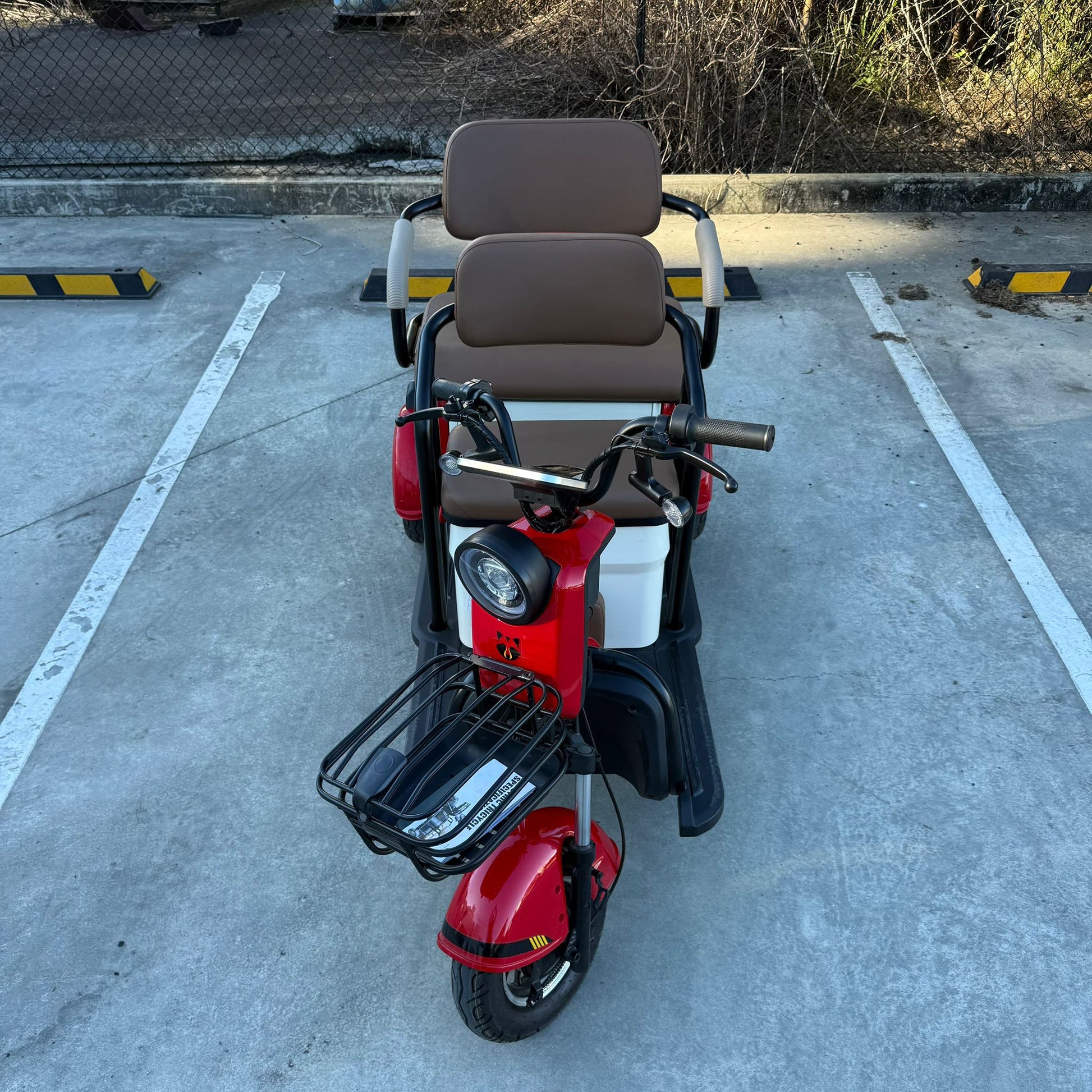 Labadi Engineering red Wheel Trike with cushioned seats and front basket on concrete surface