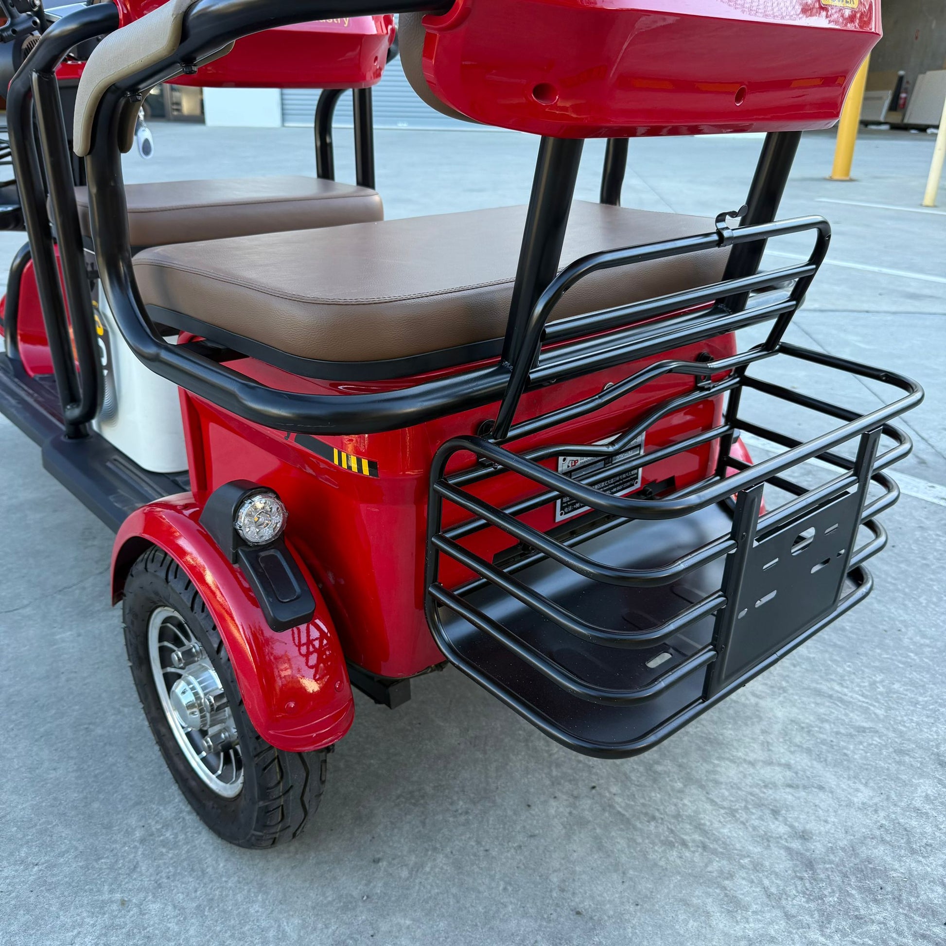Red three-wheeled Wheel Trike by Labadi Engineering with brown cushioned seats and black metal basket